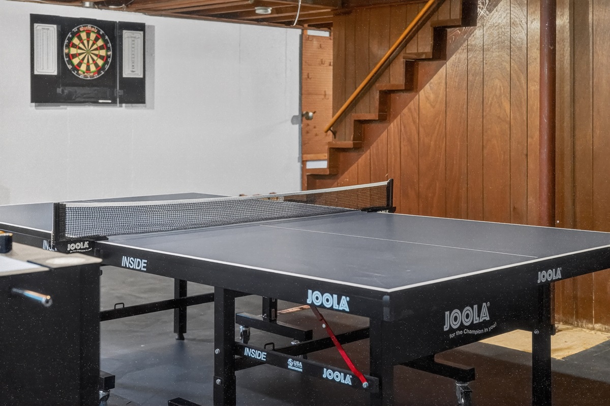 A fun-filled basement game area with ping pong, darts, and foosball for everyone to enjoy!