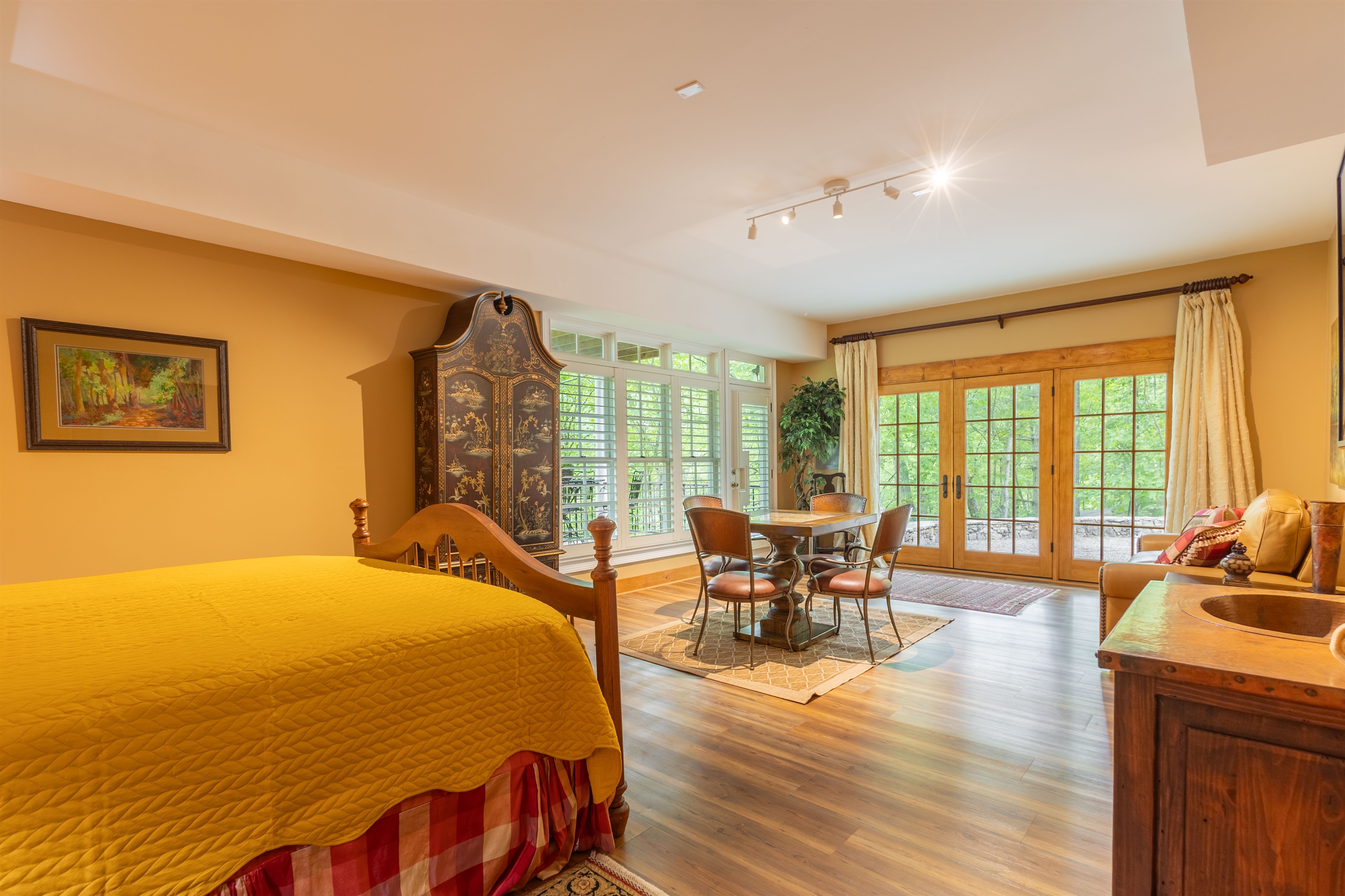 French doors fill the lower-level suite with natural light and create easy access to the peaceful outdoor space just beyond the room.