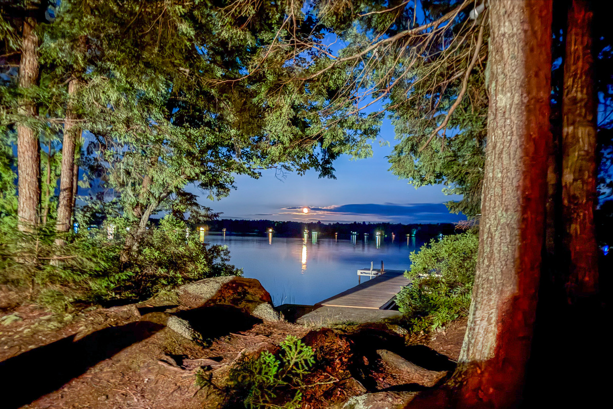 Enjoy night access at Loonrise Point! Exterior grounds lighting illuminates the pine path and granite rocks down to your private dock. Walk down safely after dark to watch the moon rise over Beech Hill Pond in peaceful Otis, ME.