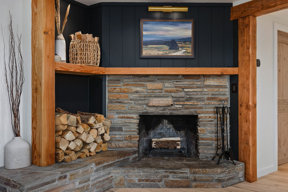 Stacked-stone fireplace and warm wood — the heart of the cabin