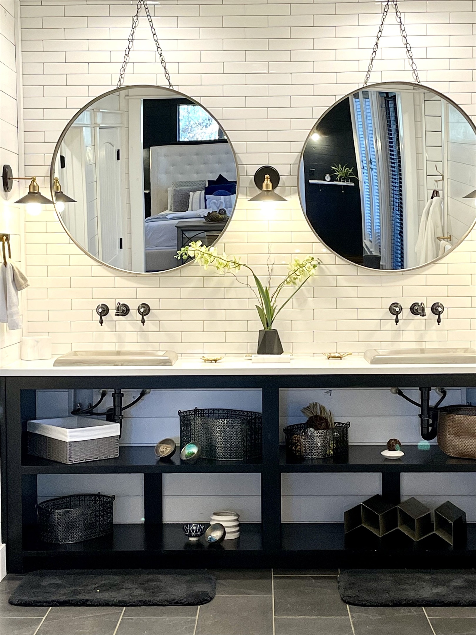 Your first glimpse of the large bathroom in First Kiss. Dual large round mirrors reflect plenty of light throughout the large bathroom. Fancy wall-mounted faucets and plenty of storage space for your personal items.