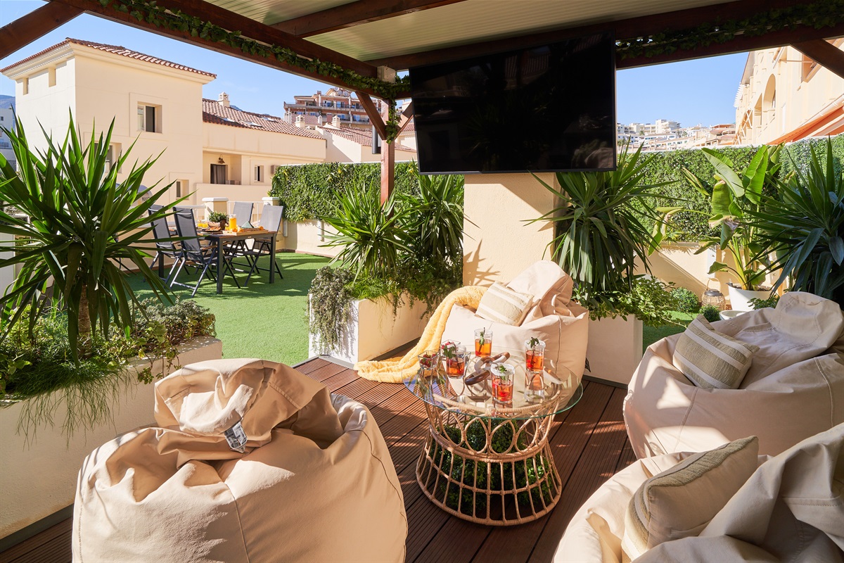 Relax beneath the covered pergola with cozy seating, fireplace, and dining area. Perfect for long evenings, romantic dinners, or movie nights on the outdoor TV under soft ambient lights.