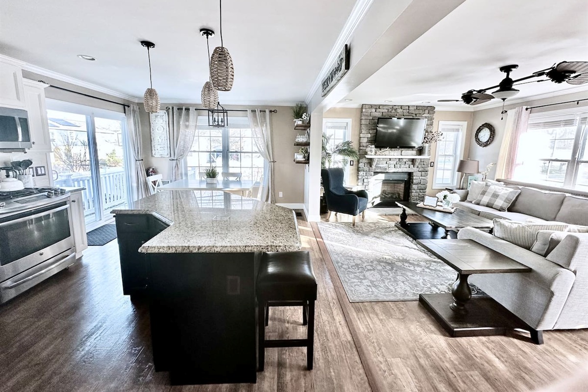 Experience the best of open-concept living in this bright, airy space. Guests can easily move from the modern kitchen with its large granite island to the cozy living room, making it the perfect hub for socializing and shared meals.
