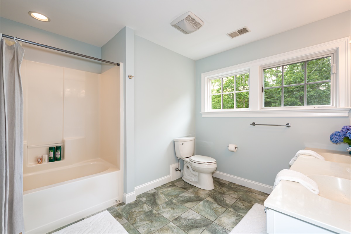 Upper-level shared bathroom with a full tub