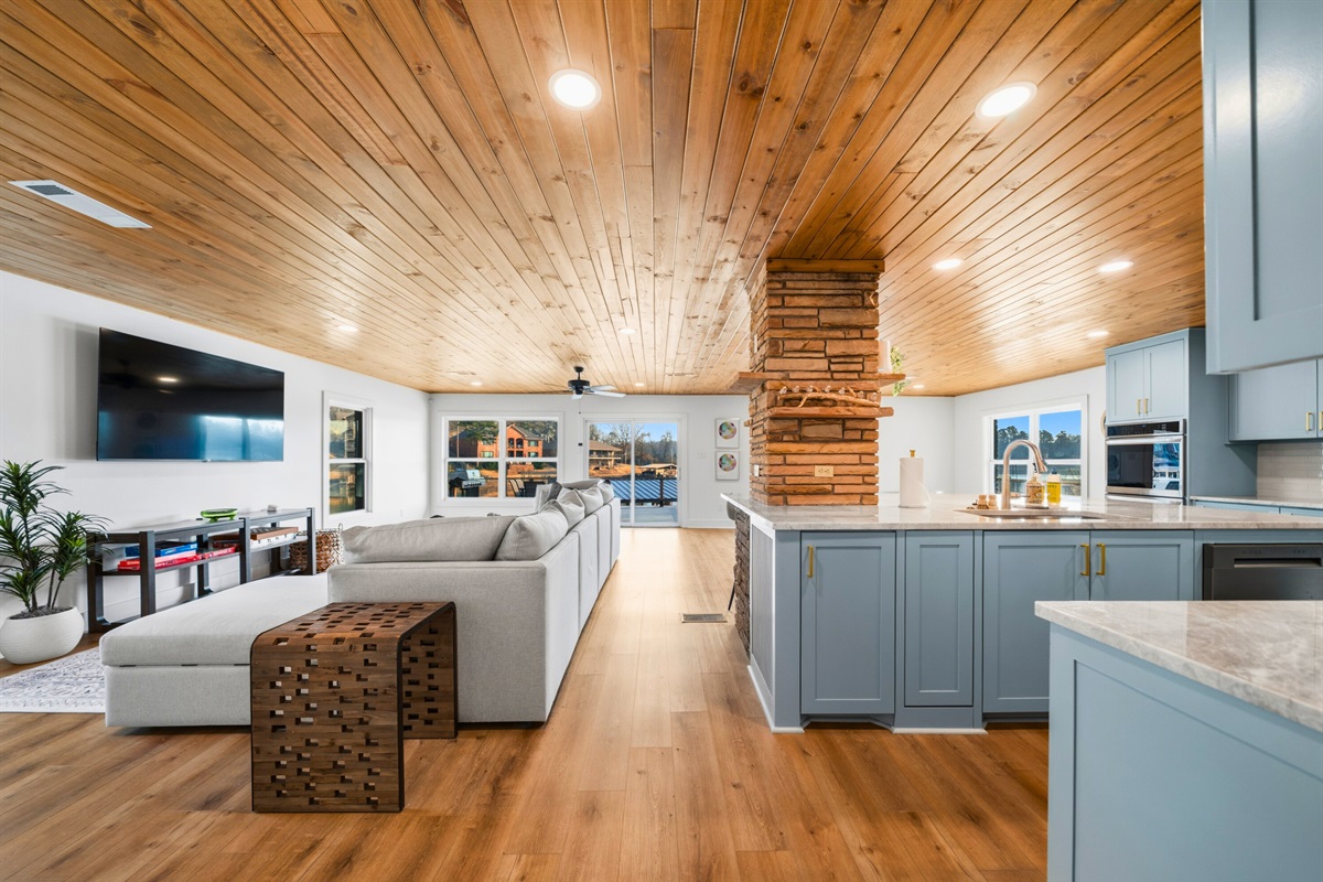 Step inside to a bright, open living area with soaring wood ceilings, comfortable seating, and a spacious layout designed for relaxing together after a day on the lake.
