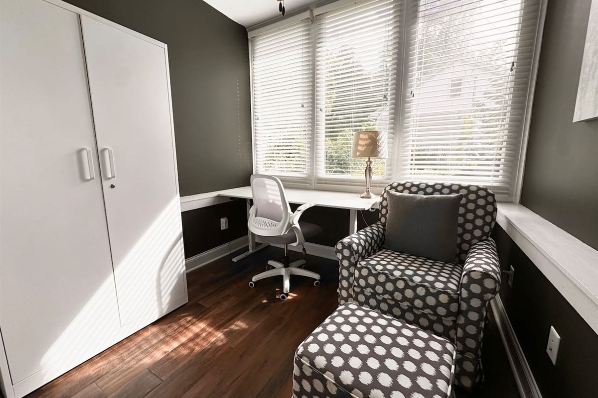 The sunny Garden Level Office includes an electric standing desk and rocking chair.