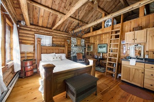 Main room of the cabin with the bed and kitchen