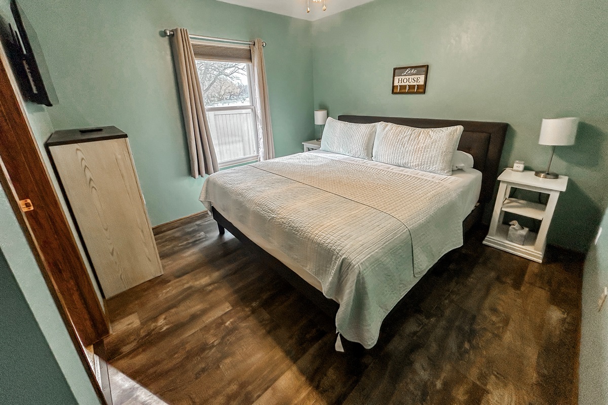 [Bedroom #1] King bed with TV and half bathroom.