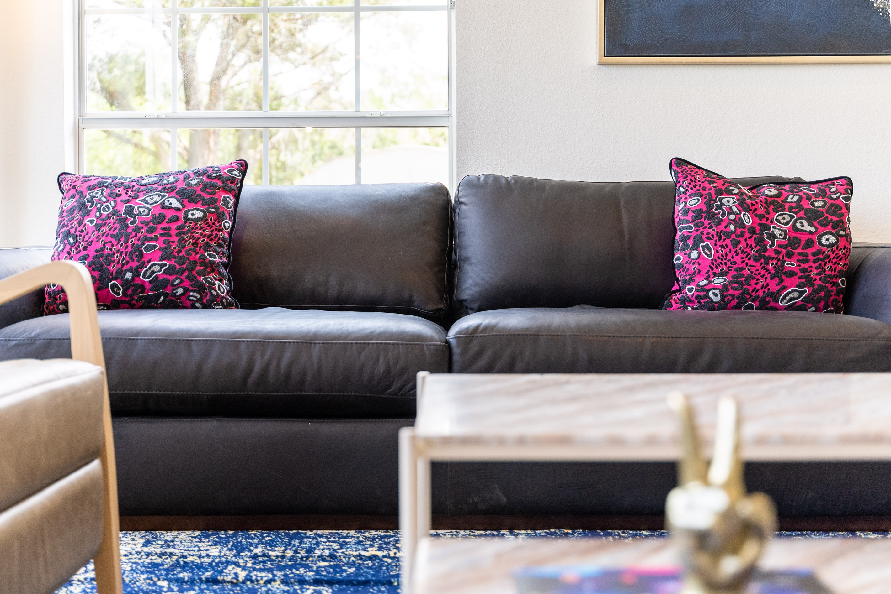 Jewel-toned throw pillows add a playful pop of color to the sofa.
