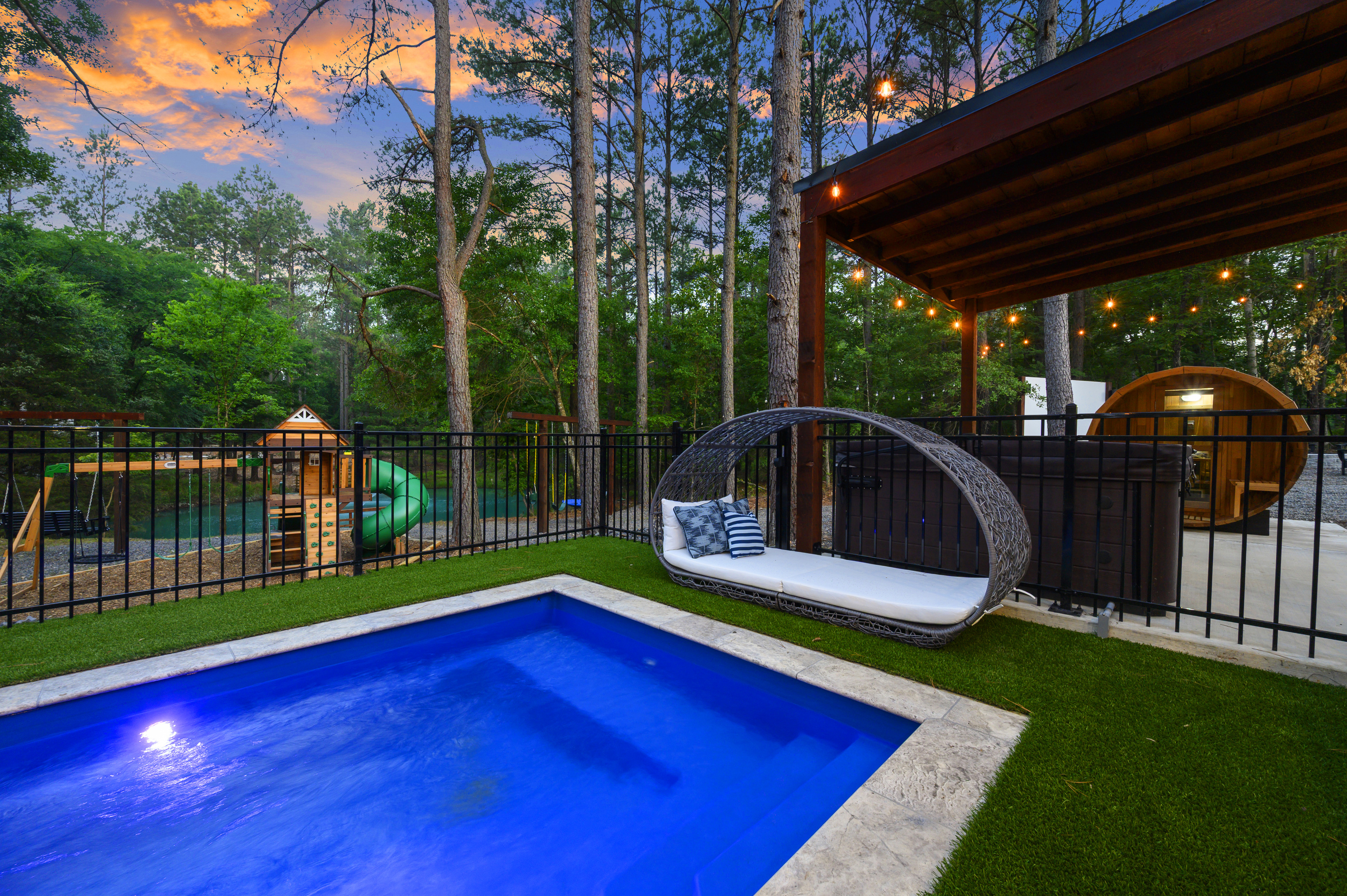 Private resort in the pines: heated pool, hot tub, sauna + playset here, with pickleball, basketball, fire pit & outdoor cinema just around the other side.