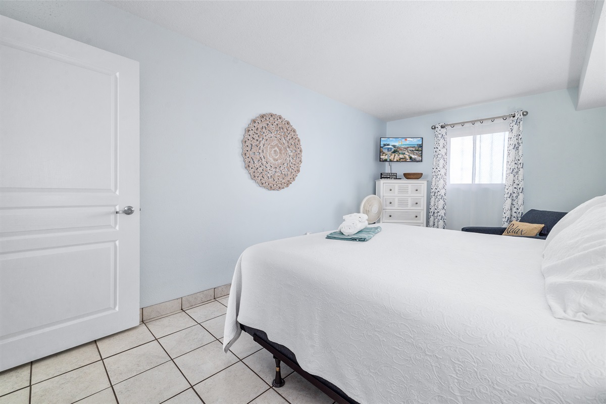 Soft linens, fresh design create a peaceful place to rest. A kitchen between bedroom and main living space provides privacy and minor separation of the spaces