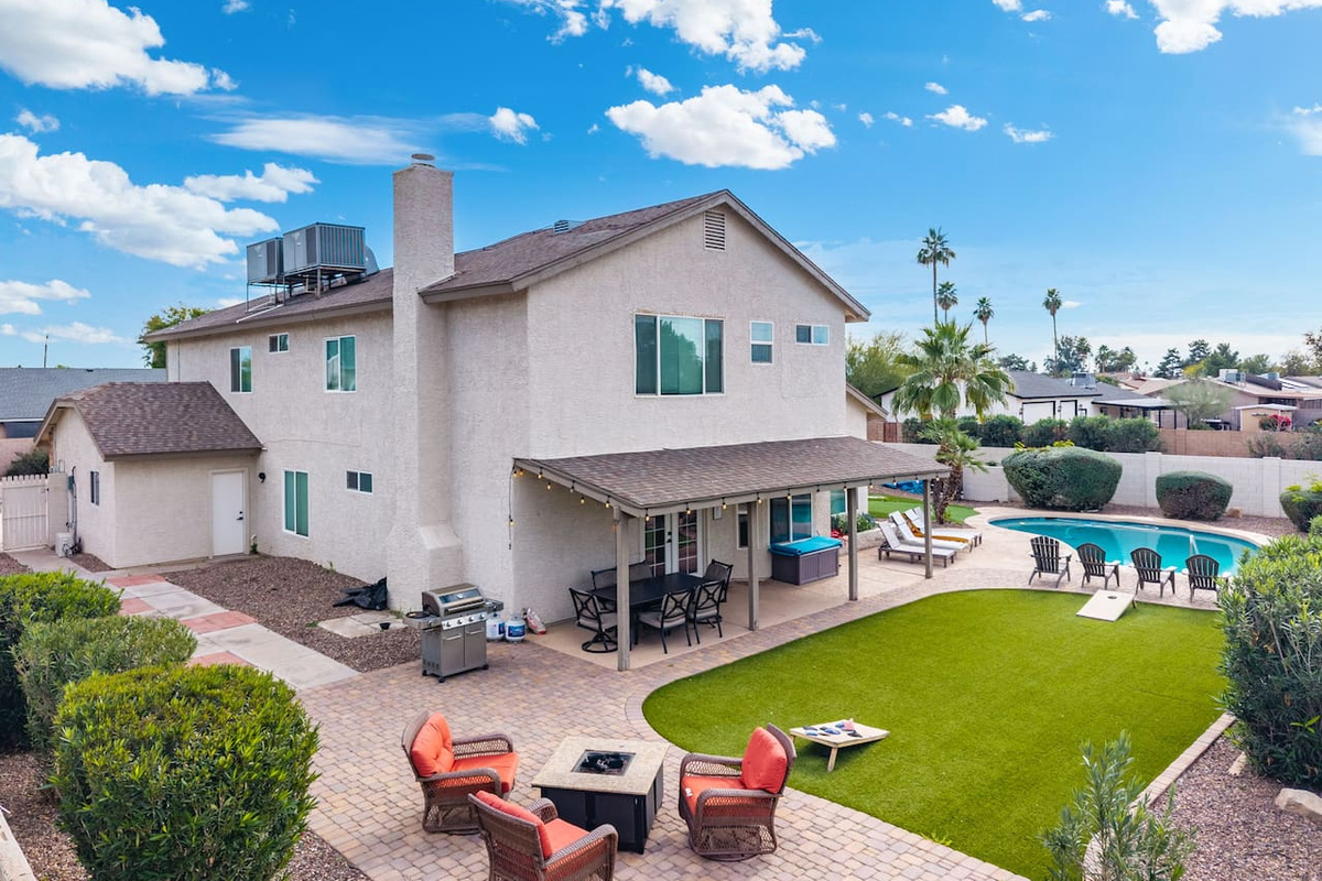 Backyard oasis with pool, covered patio, firepit, and manicured lawn—perfect for relaxation and gatherings.