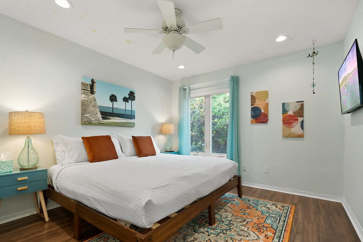 A king bed under a slowly turning ceiling fan, with a smart TV on the wall. Sign into your own Netflix or Hulu, pull the curtains against the morning, and sleep as late as the holiday will possibly allow.