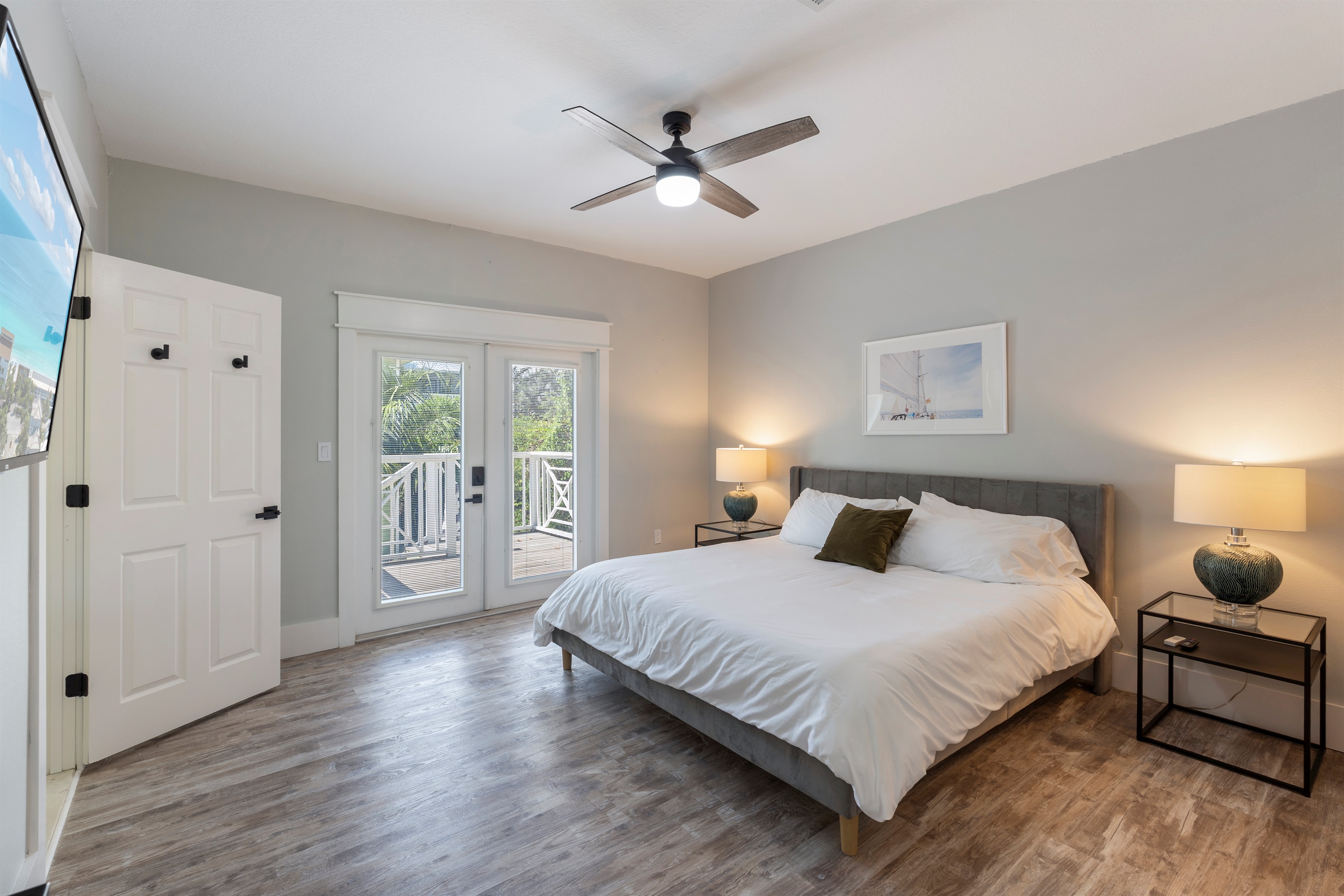 Primary bedroom with king bed. The doors lead to outdoor deck and the backyard 