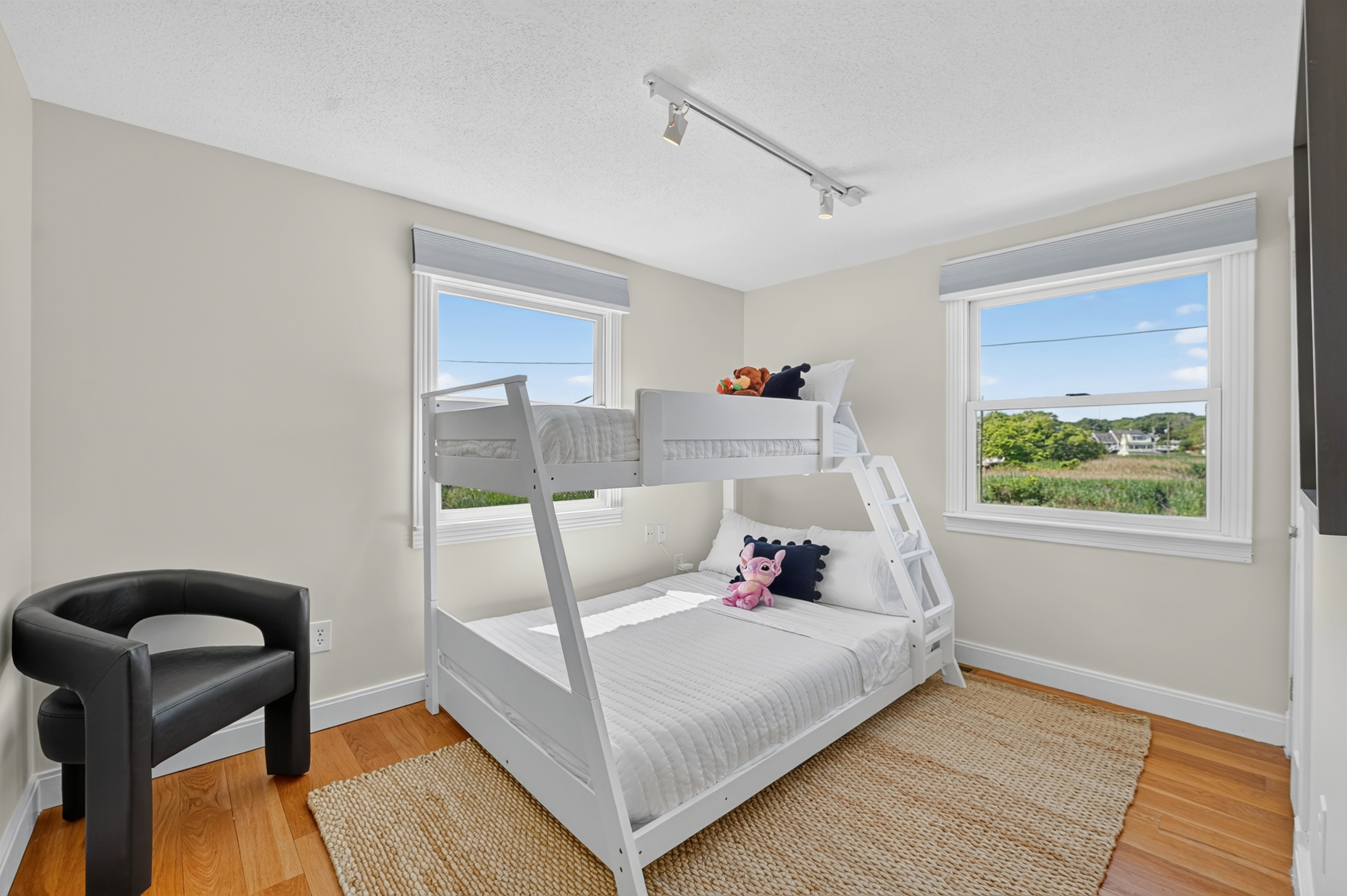 Family-friendly bunk room with multiple sleeping spaces and bright windows overlooking the surrounding coastal scenery.