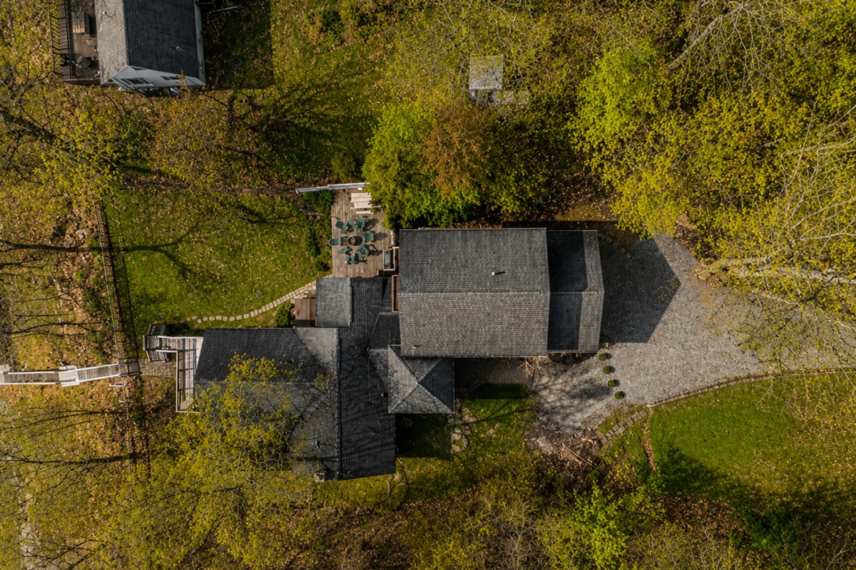 Experience this expansive property from a unique aerial perspective, showcasing its lush green spaces and multiple structures, perfect for large gatherings or peaceful solitude. 