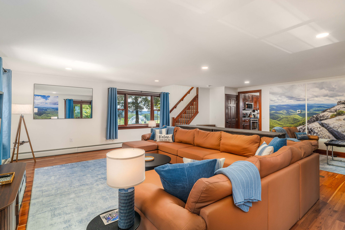 🛋 Open main-level living space with electric fireplace, big windows and real mountain photography on the walls.