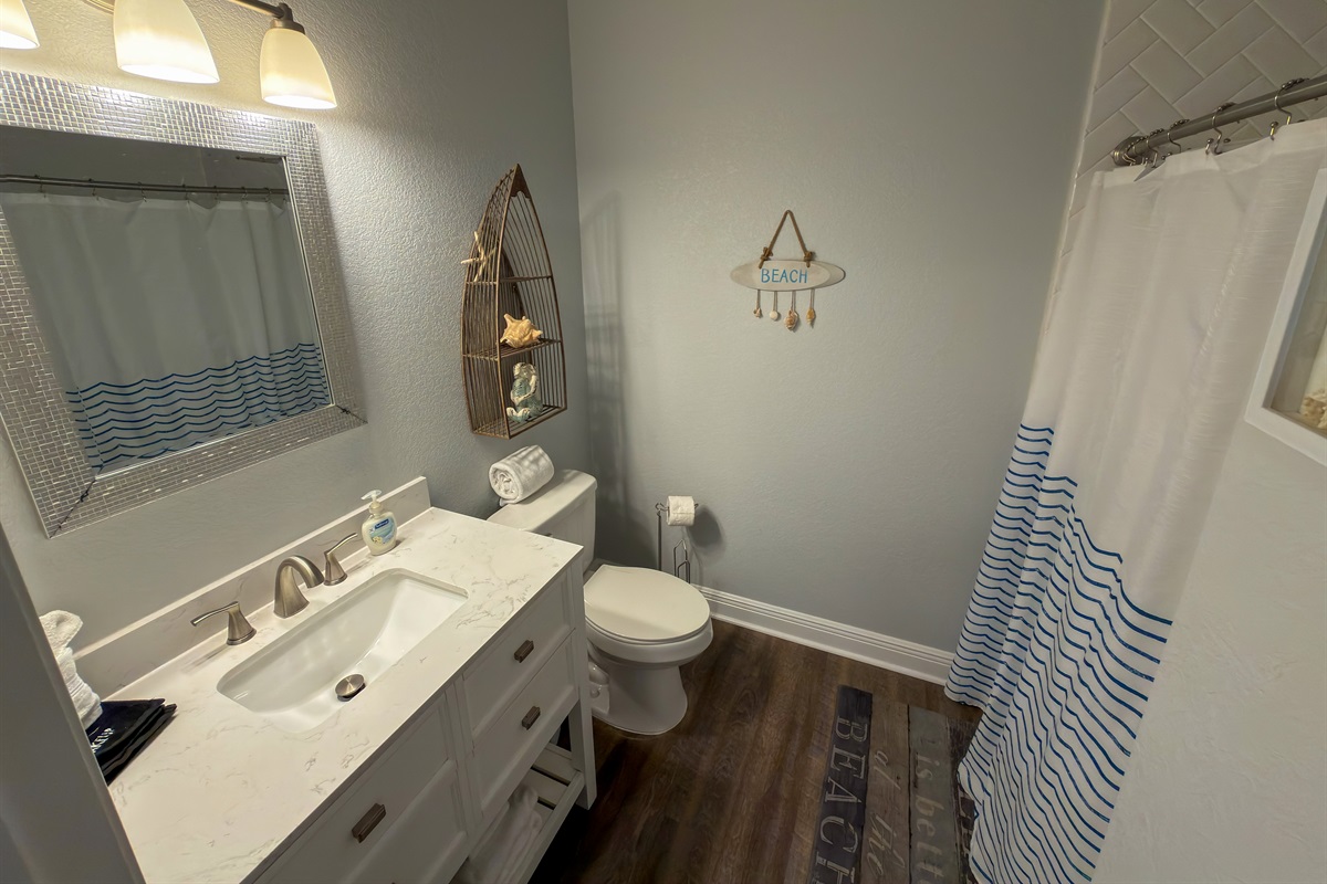 Ensuite Bathroom 1 features a spacious walk-in shower and cheerful nautical accents that reflect the home’s coastal aesthetic.