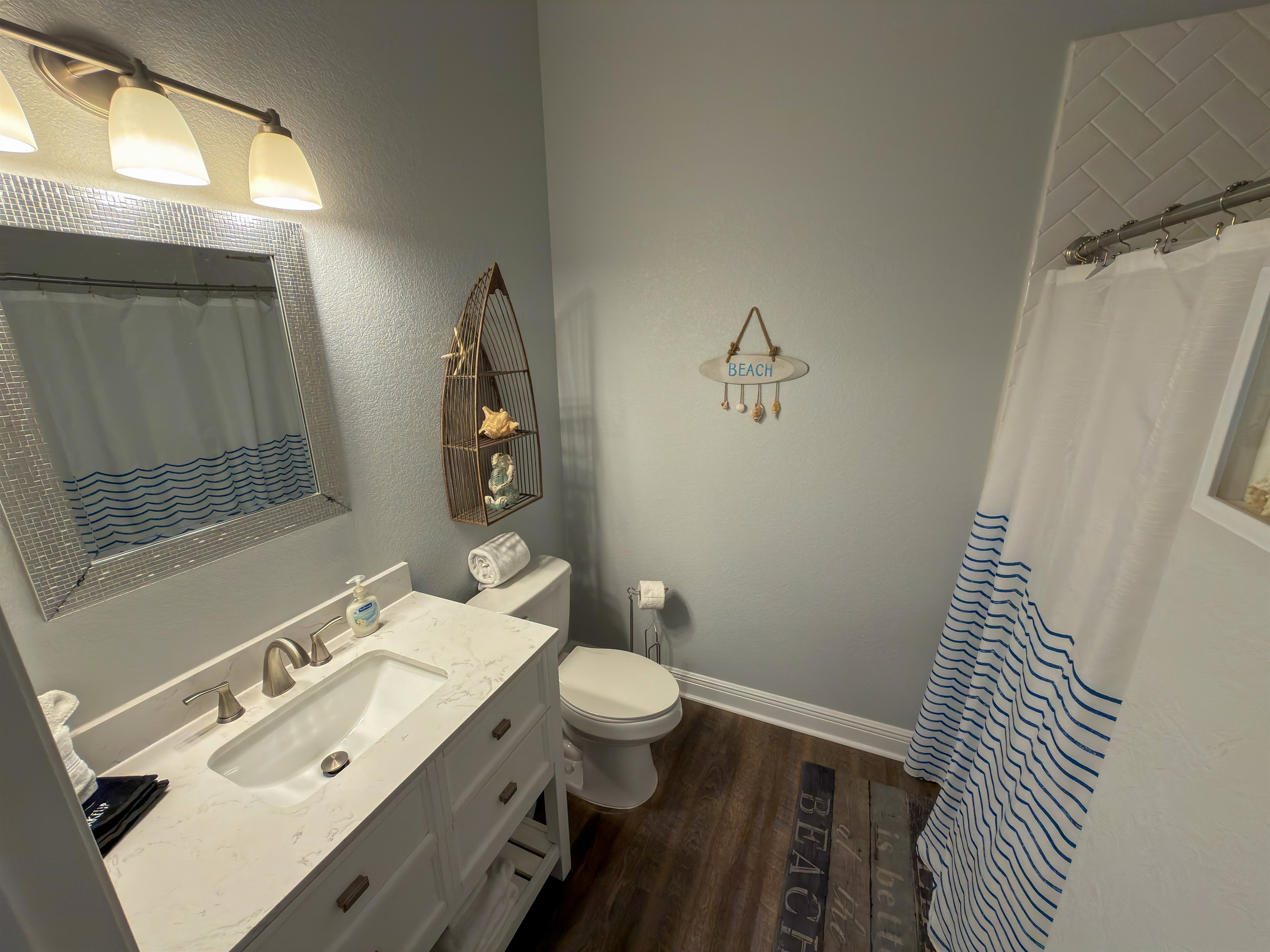 Ensuite Bathroom 1 features a spacious walk-in shower and cheerful nautical accents that reflect the home’s coastal aesthetic.