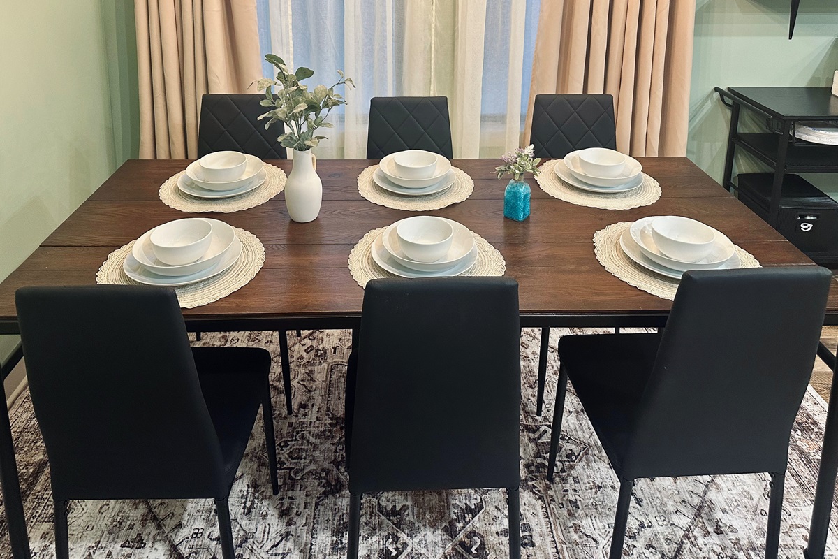 Alternate view of the dining space showcasing the welcoming layout and full place settings for six guests.