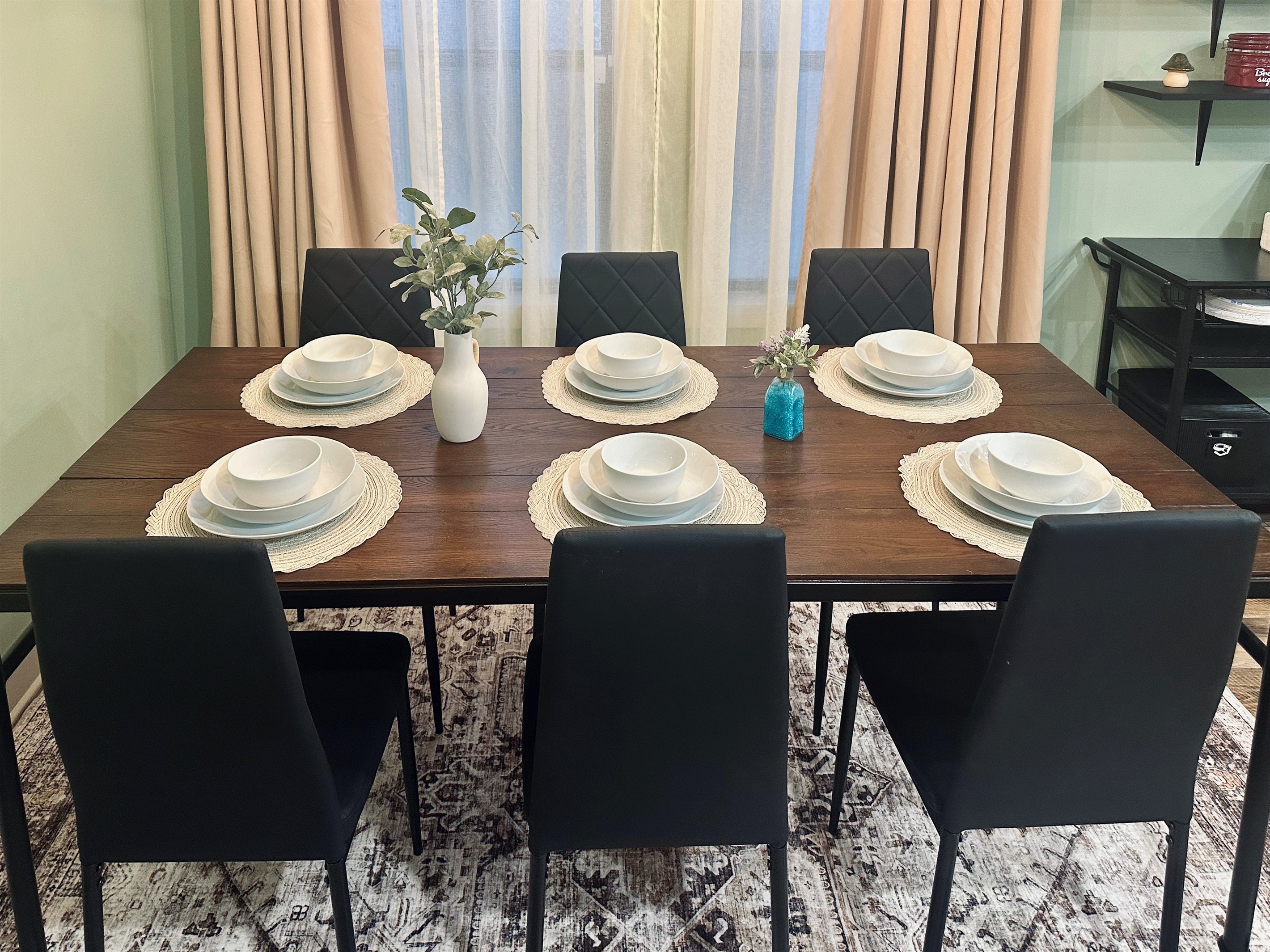 Alternate view of the dining space showcasing the welcoming layout and full place settings for six guests.