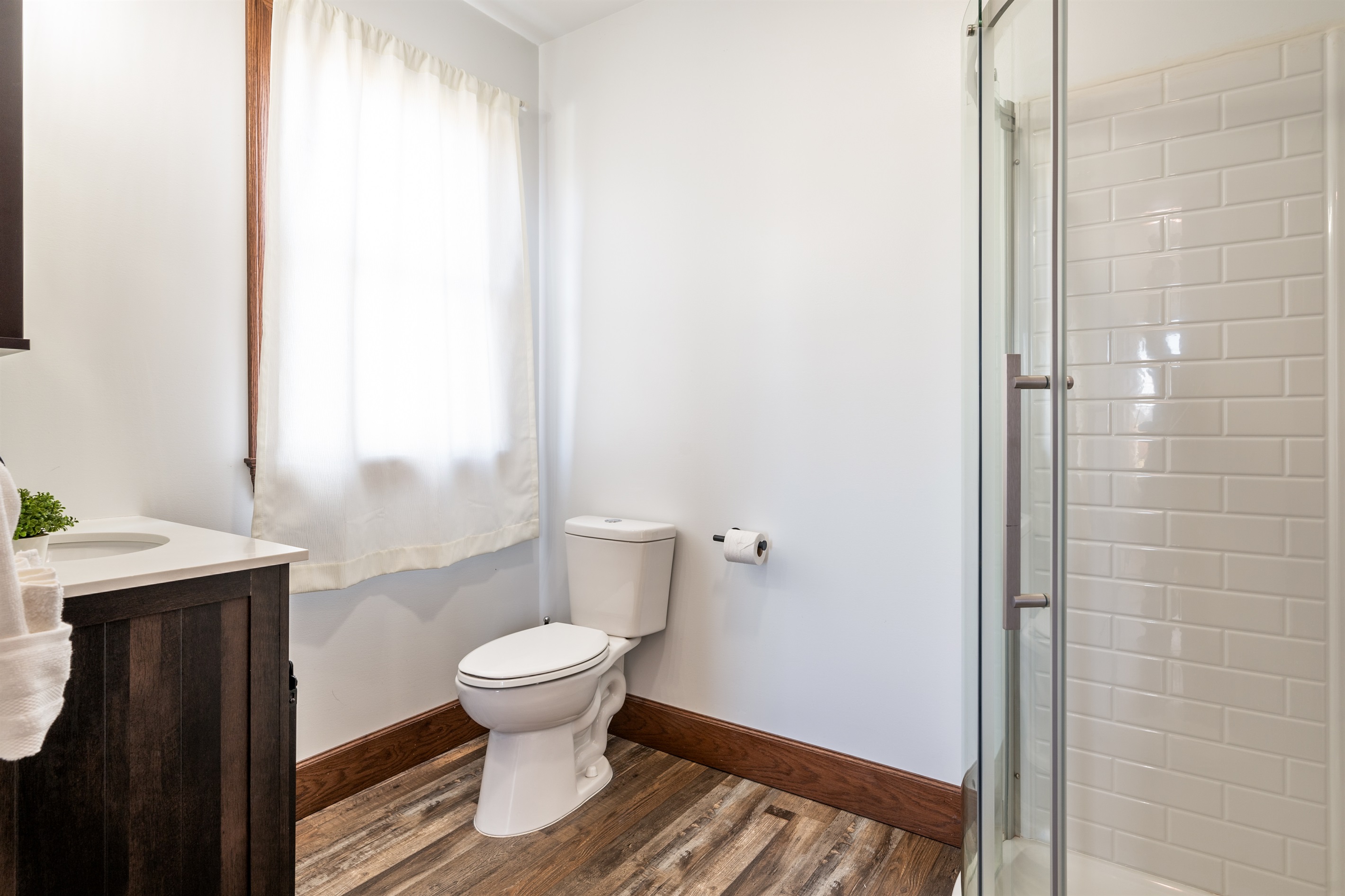 Clean, classic bathroom with shower/tub combo and soft natural lighting.