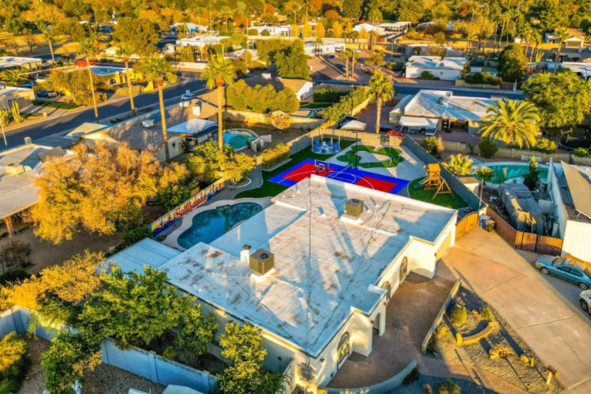 Pool, court, and putting green all visible in one frame — the kind of layout that lets everyone do their own thing at once.