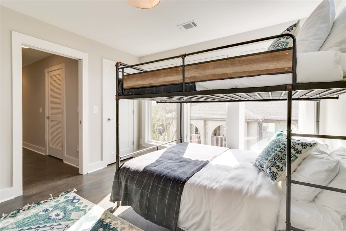 - Full size bottom and twin top bunk framed by oversized windows & natural light - Soft layered bedding with patterned pillows create a cozy and inviting sleep space - Easy access to hallway & shared areas makes this room perfect for families or groups