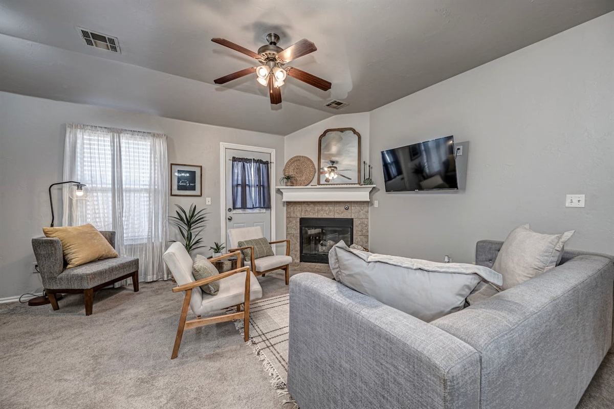 Spacious living area featuring comfortable seating, smart TV, and a warm fireplace.