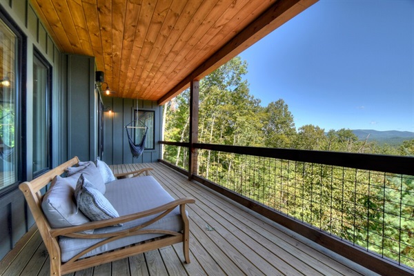 Daybed and hanging chairs overlook the mountains