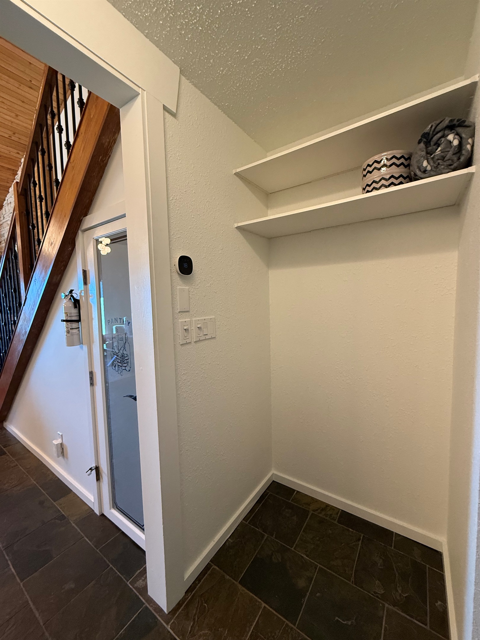 Mudroom Access: The open entryway provides a clear path to the main floor and staircase, with integrated shelving for additional storage solutions.
