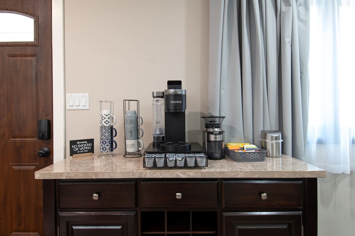 Coffee/tea bar with coffee grinder. Bar has some coffee and tea to get you started until you go grocery shopping. There is also sugar and powdered creamer.