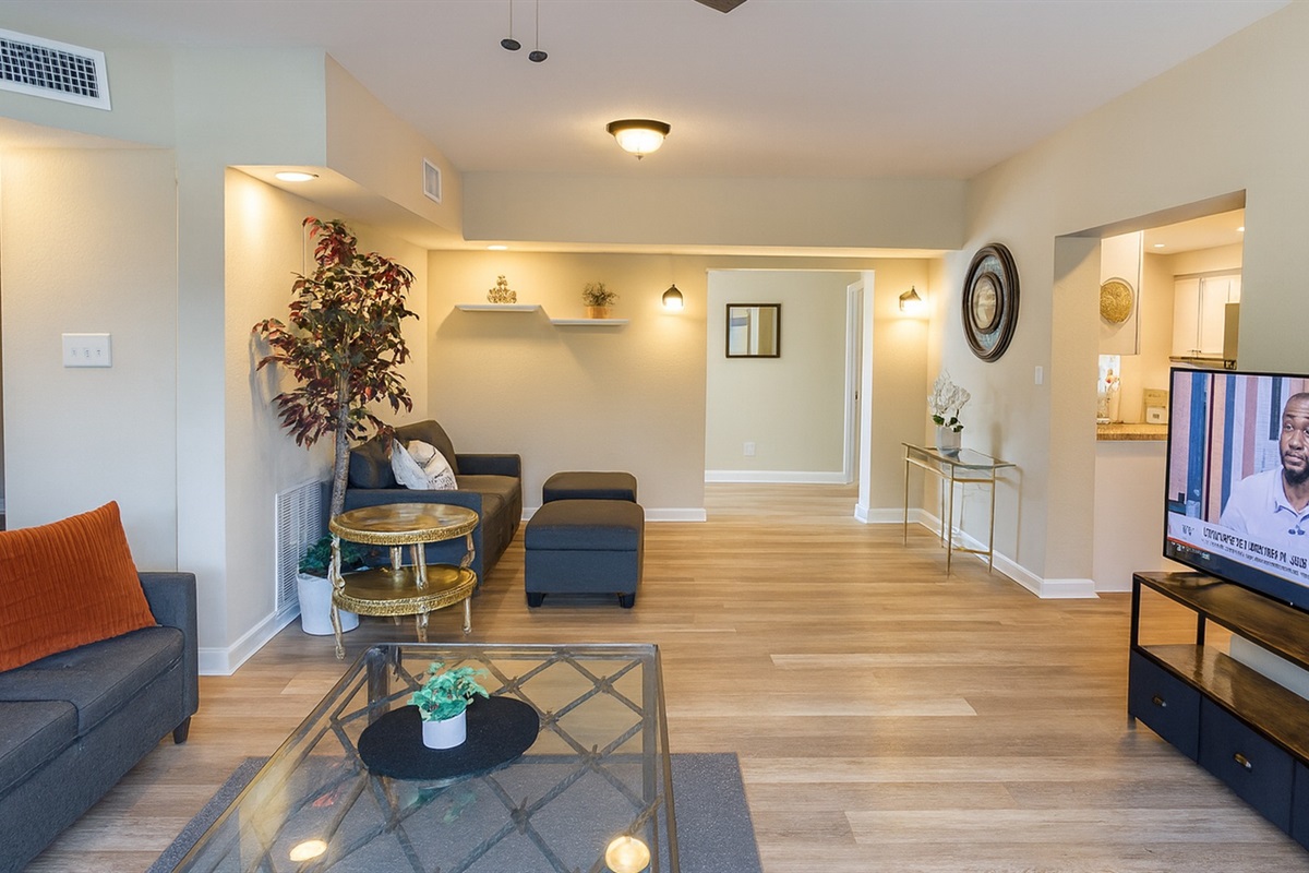 Open-concept living room with stylish coastal décor, smart TV and comfy seating—perfect for relaxing after exploring Madeira Beach and John's Pass from our 5-bed midterm rental in Seminole.