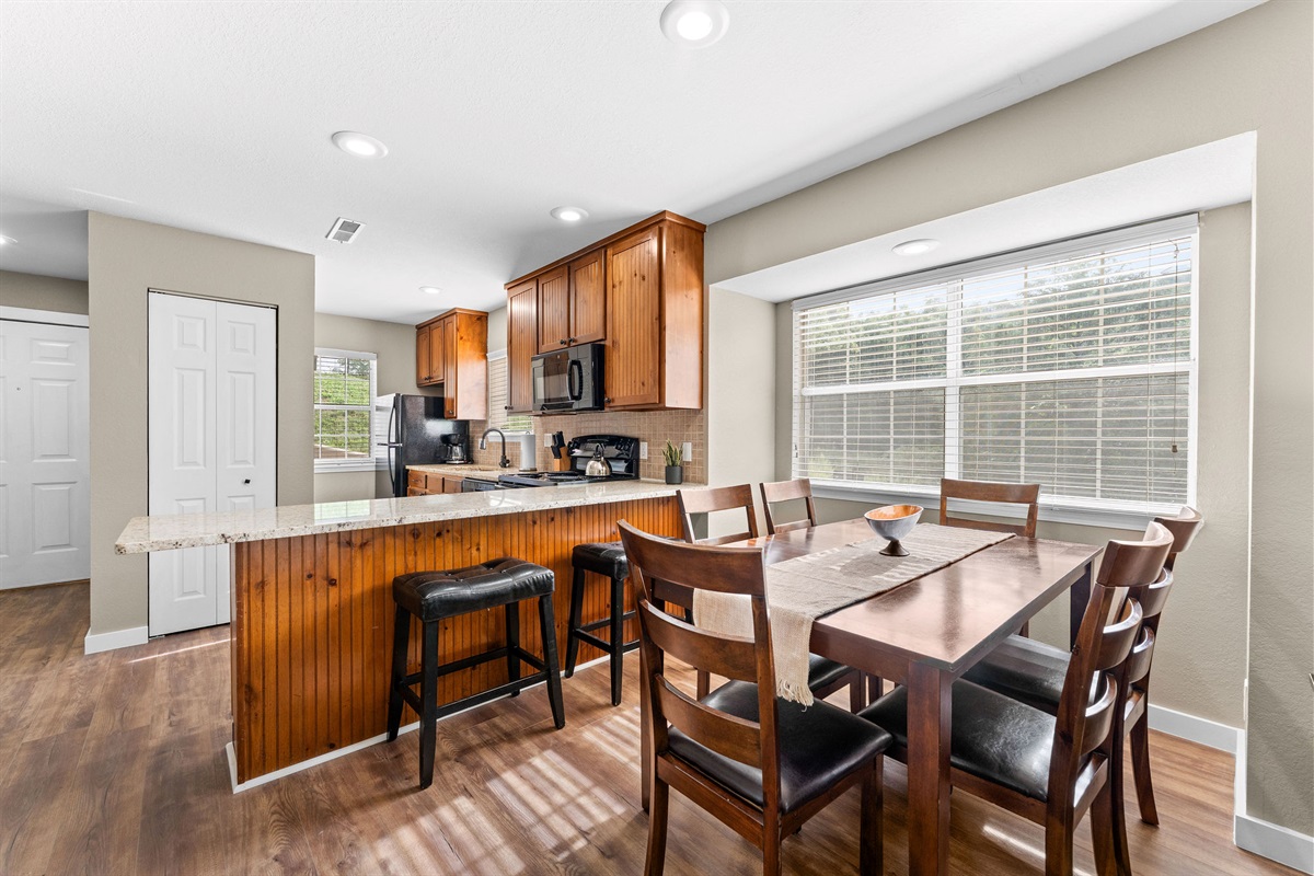 Open kitchen with breakfast bar and dining table for six