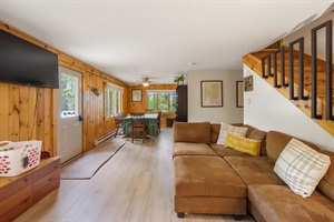 Living room with couch, tv and dining room on the background