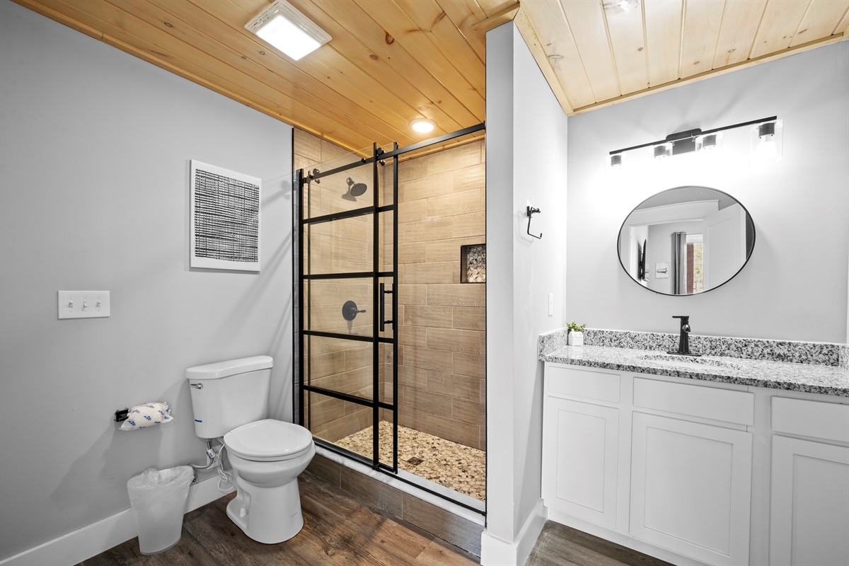 Full bathroom with modern finishes, granite countertop, and walk-in shower. Clean, bright, and well-equipped for group stays.