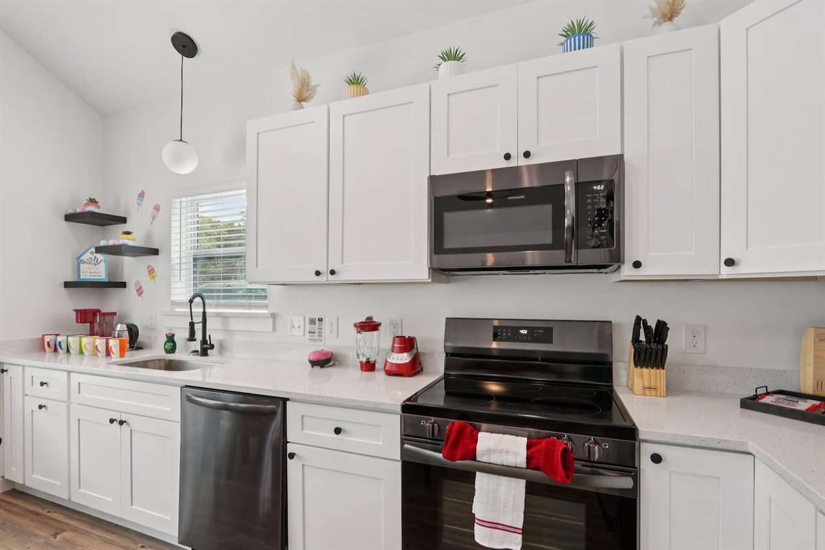 Coffee mugs with Keurig coffee maker (pods included), hot water heater, mini waffle maker, blender, stove, oven, dishwasher, fridge, filtered water, knives, cutting board, pots/pans, baking sheets, utensils.  