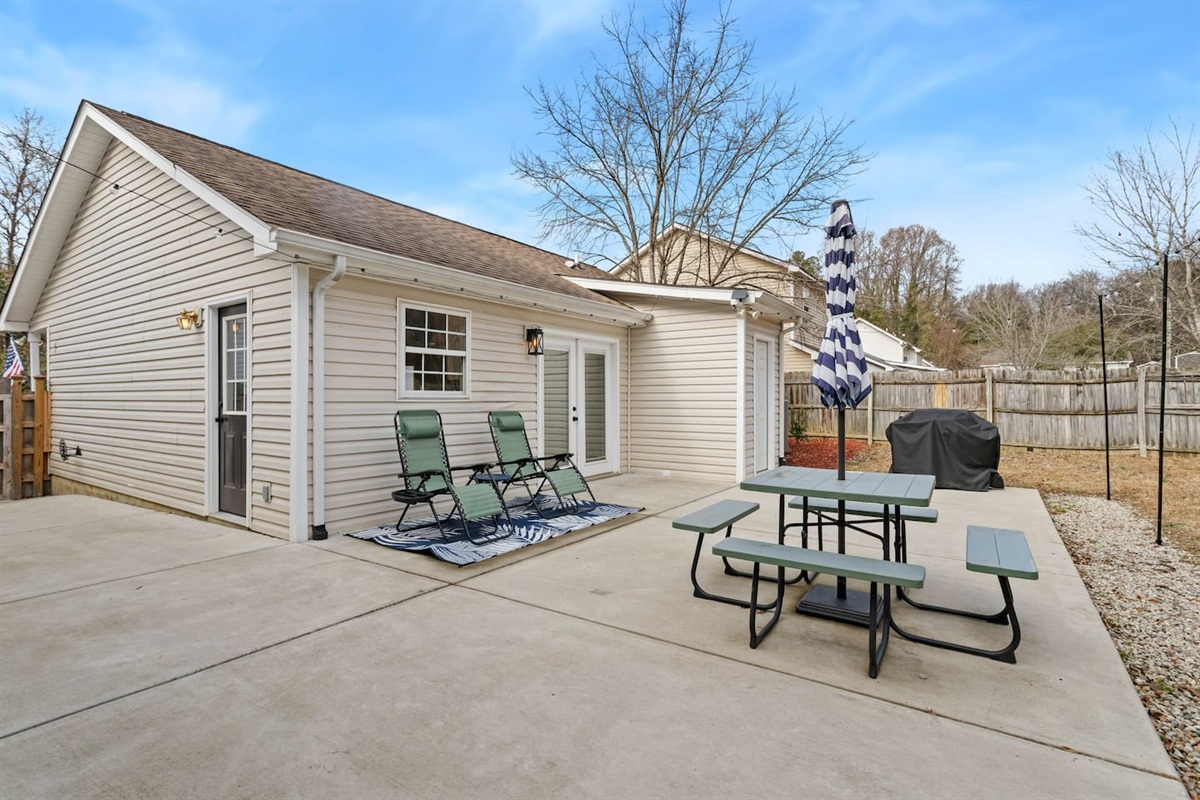 Private outdoor space with new fence, grill, and string lights for ambiance! 