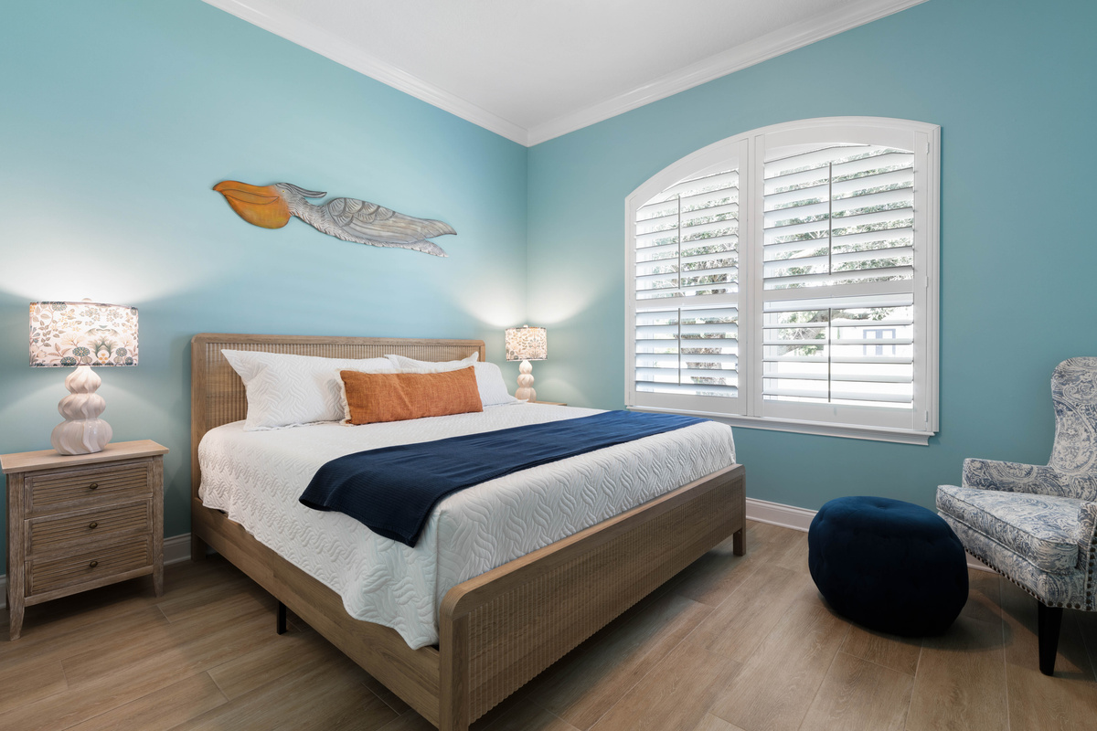 Navy throw, carved pelican and a wingback chair with a pouf give the Aqua Blue room a relaxed coastal feel.