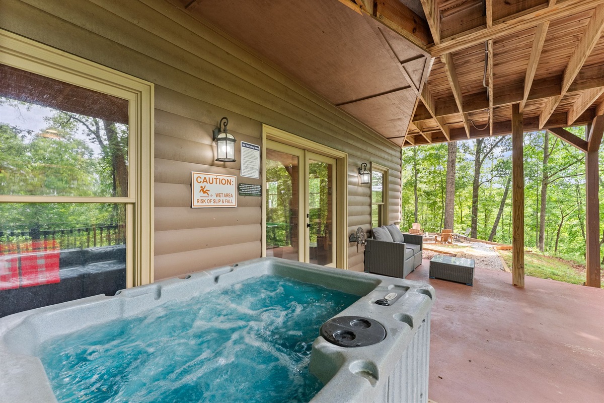 Covered hot tub surrounded by peaceful woodland scenery.