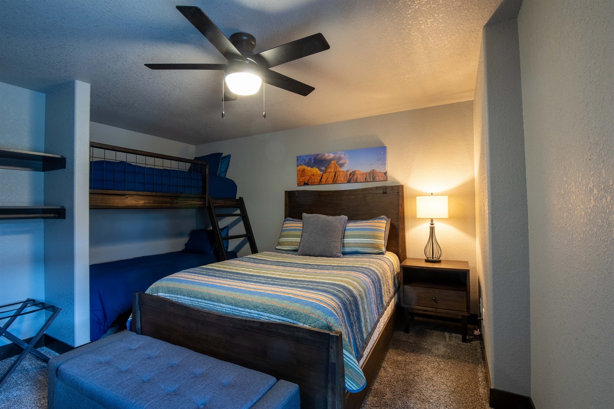Perfect for families or groups, this lower-level bedroom features a cozy queen bed and 2 sets of twin bunks—plenty of space for kids, teens, or extra guests to rest and recharge.