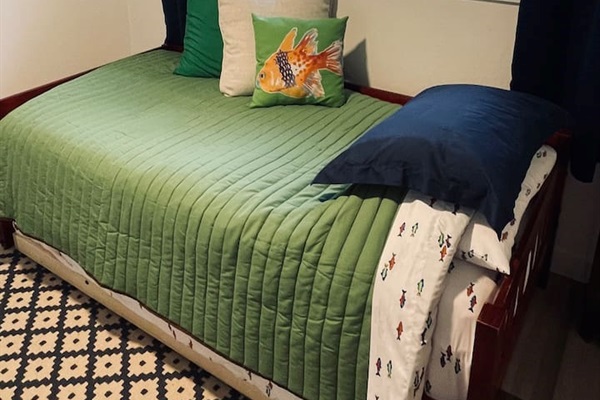 A whimsical space for kids with twin and trundle beds, where ocean creatures and moonlit adventures inspire imagination, all with a peaceful lake view just beyond the window.