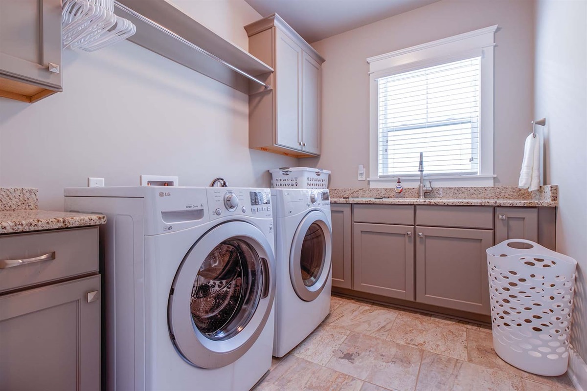 Oversized laundry room with sink. Detergent, fabric softener, and dryer sheets are provided.