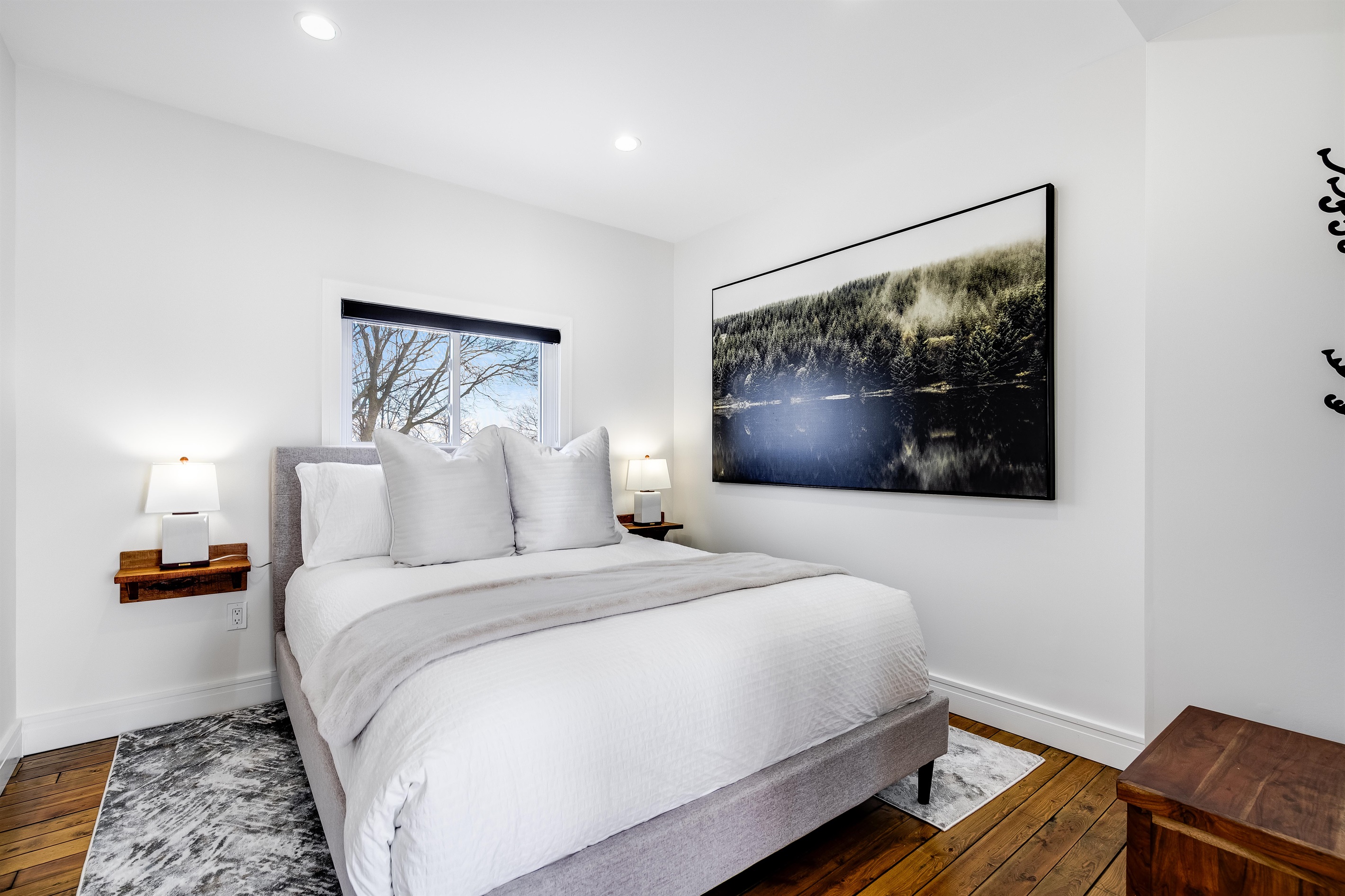 A serene Queen bedroom retreat with white and natural wood.