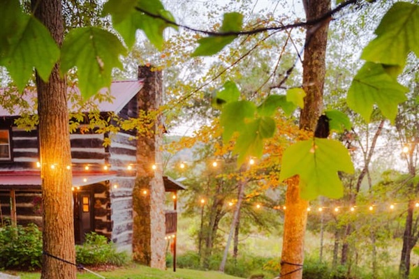 Soak in the peaceful outdoors, with twinkling lights gently illuminating the trees.