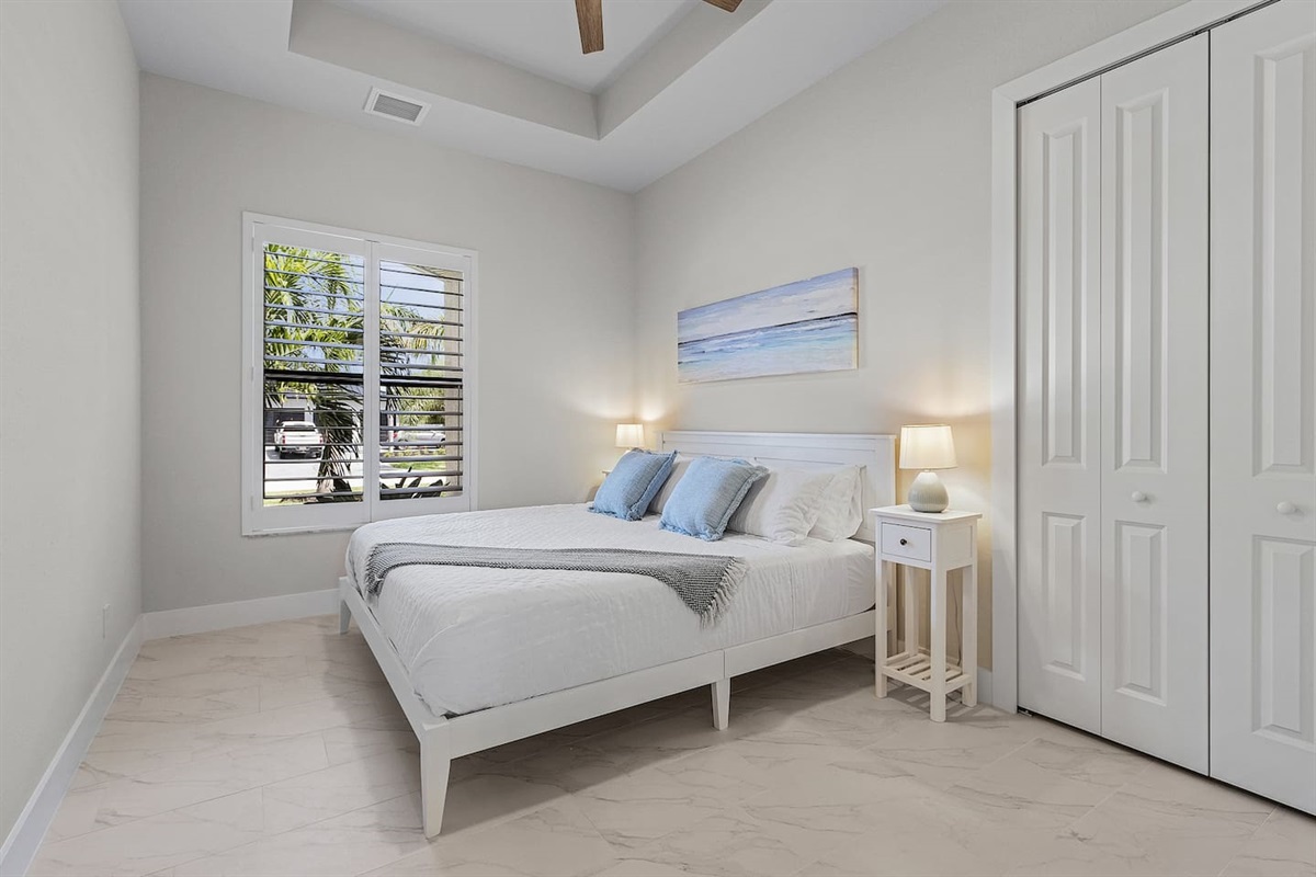 1st Guest bedroom featuring a king-size bed and elegant coastal design, creating a serene retreat for restful nights!