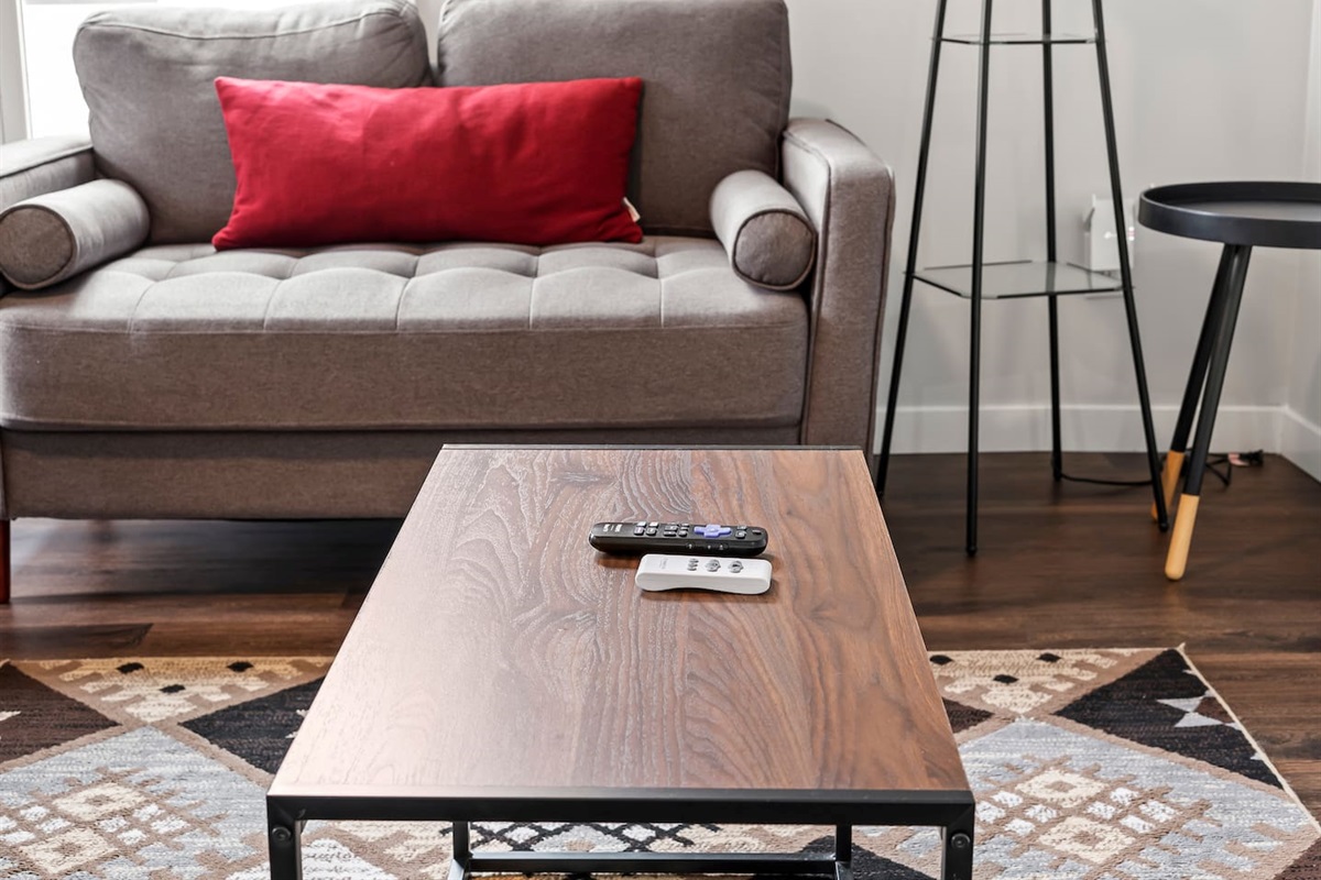 Cozy details like plush seating, patterned rug, and a pop of color make this space inviting.
