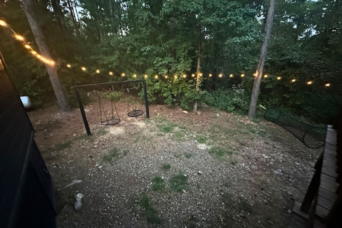 A fenced backyard retreat surrounded by trees, perfect for pets or simply enjoying the outdoors.