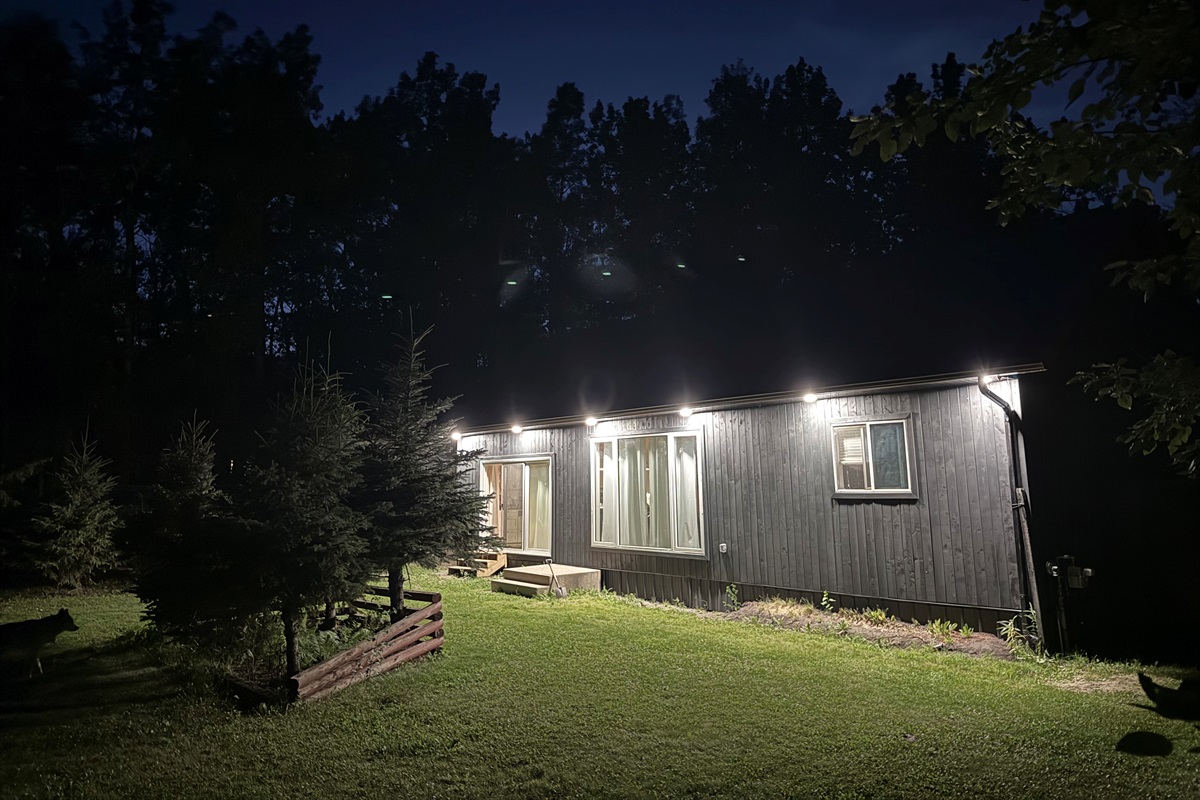 Side view of the cabin at night surrounded by forest