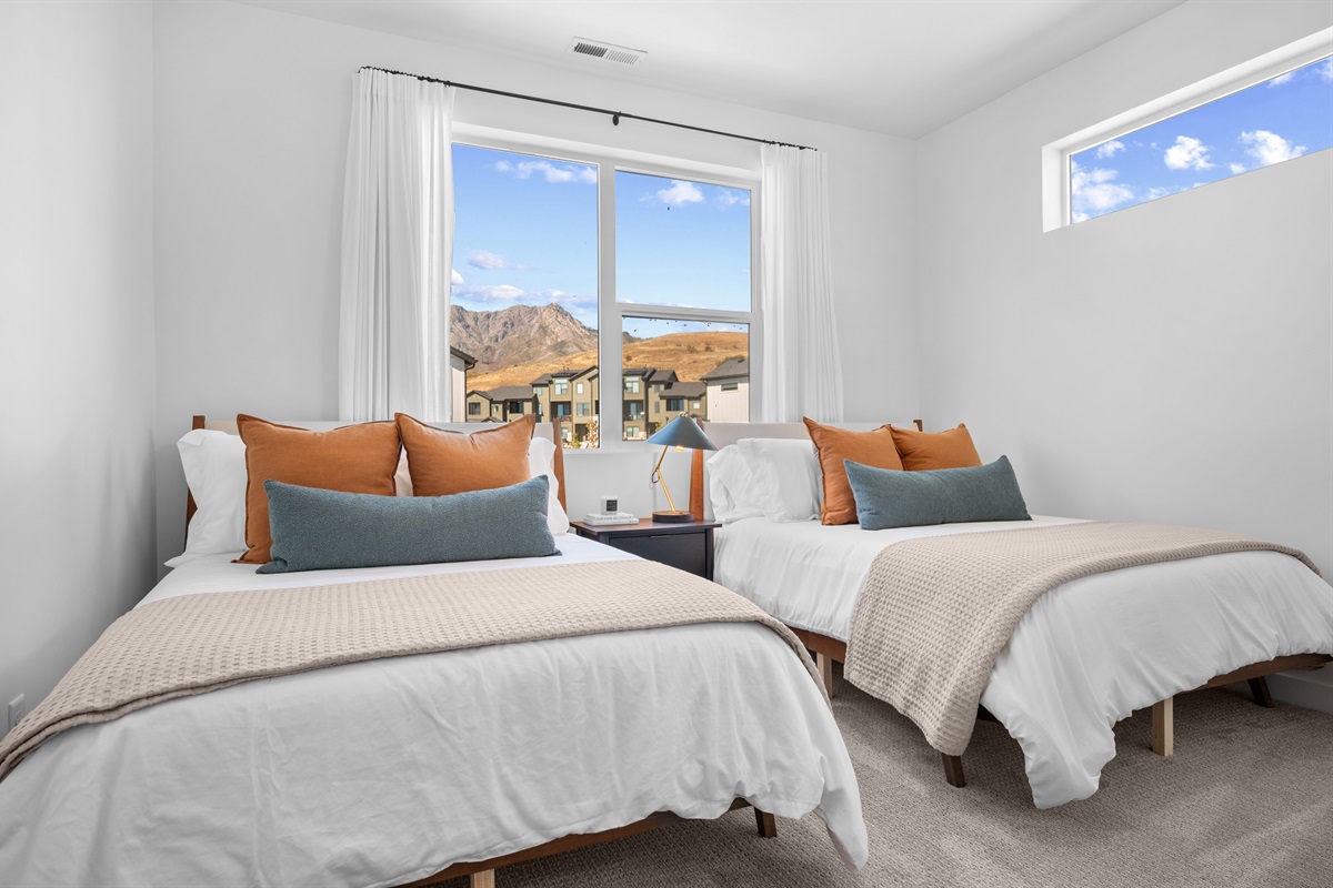 Comfortable bedroom with a view of the neighborhood and peaks.